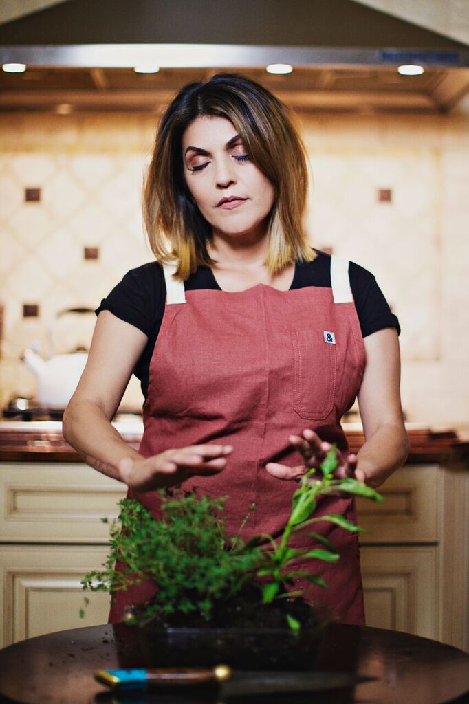 Chef Denise Portillo working with fresh herbs in a professional kitchen